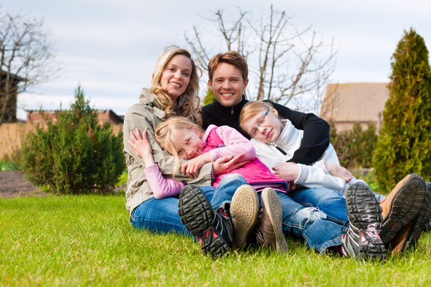 Family sitting together on a meadow in spring Premium Photo