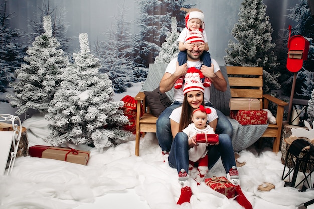 Family together at christmas in artificial forest under snowfall Premium Photo