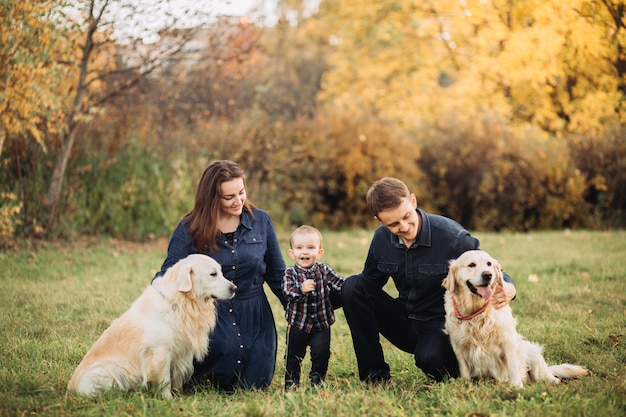 Premium Photo | Family with a child and two golden retrievers in an ...