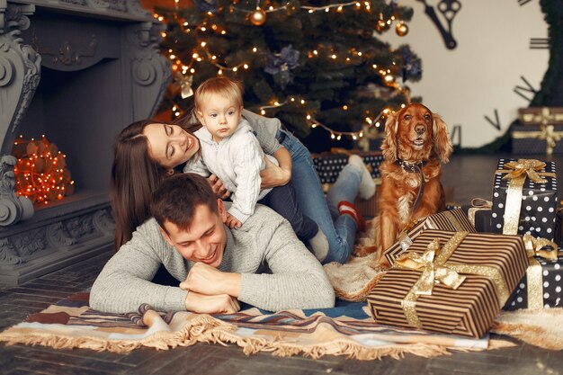 クリスマスツリーの近くに家でかわいい犬と家族 無料の写真