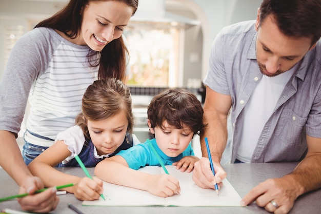 Family writing in book while standing at table Free Photo