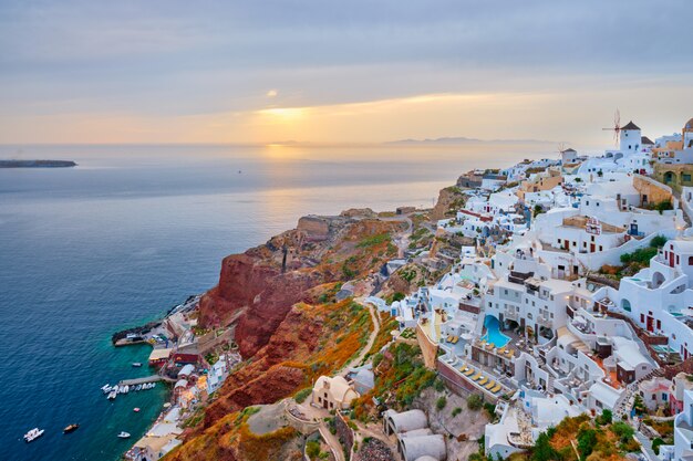 有名なギリシャの象徴的なselfieスポット観光地イア村伝統的な白い家と夕暮れ時 ギリシャのサントリーニ島の風車のある風車 プレミアム写真