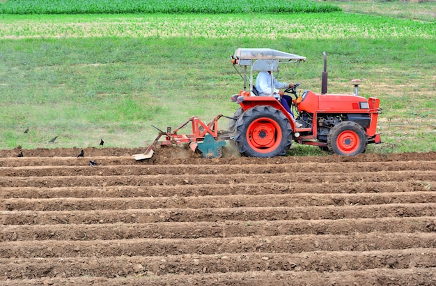 Premium Photo Farmer In Tractor Plowing Land With Red Tractor For Agriculture