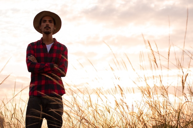 Premium Photo | Farmer with hat in farm plantation on sunset.