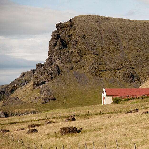 Premium Photo | Farmland and barn below grassy cliff