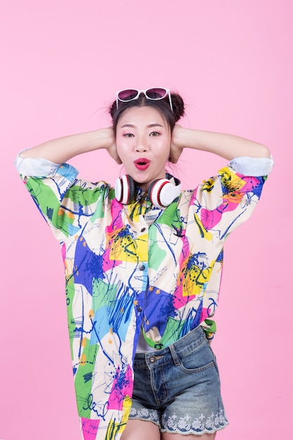 Fashion girl dress up with hand gestures on a pink background. Free Photo