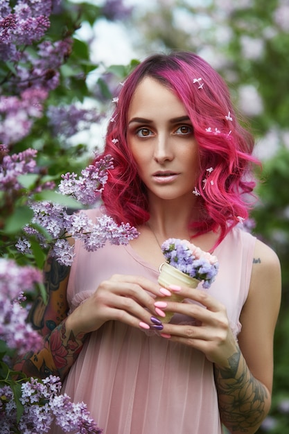 Fashion Girl With Bright Red Dyed Hair Surrounded By Lilac Flowers