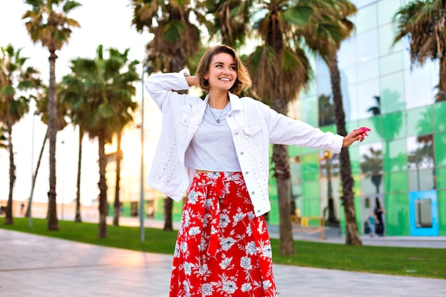 バルセロナのストリートでポーズをとるスタイリッシュな女性のファッションの肖像画 手のひら ネオンサングラス 旅行気分 カジュアルなヒップスターの服 喜び 自由な精神 無料の写真
