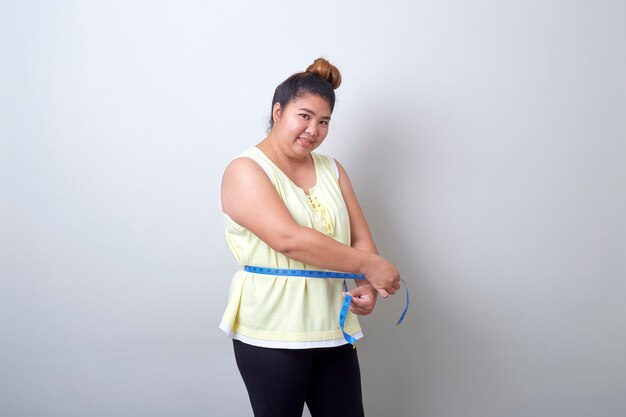 Premium Photo | Fat asian woman measuring