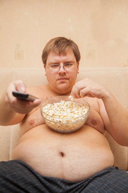 fat-man-with-beer-belly-front-tv-eating-popcorn_262114-190.jpg