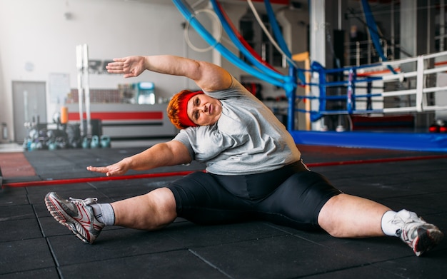 Premium Photo | Fat woman exercises on the floor, workout in gym ...