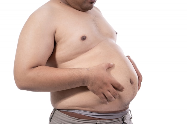 太った若い男は彼の腰の周りにある余分な脂肪をつまむ プレミアム写真