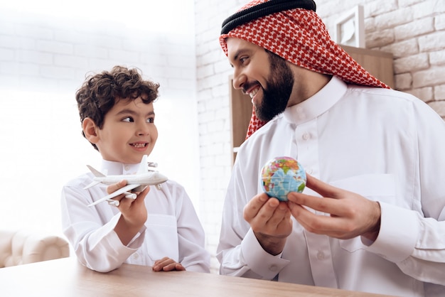 Father arab tells son about flight of aircraft. Premium Photo
