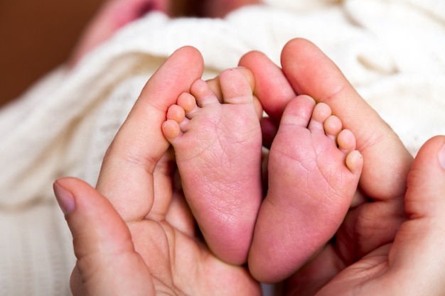かわいい美しい白人新生児男の子小さな足 1週齢を保持している父の手 プレミアム写真