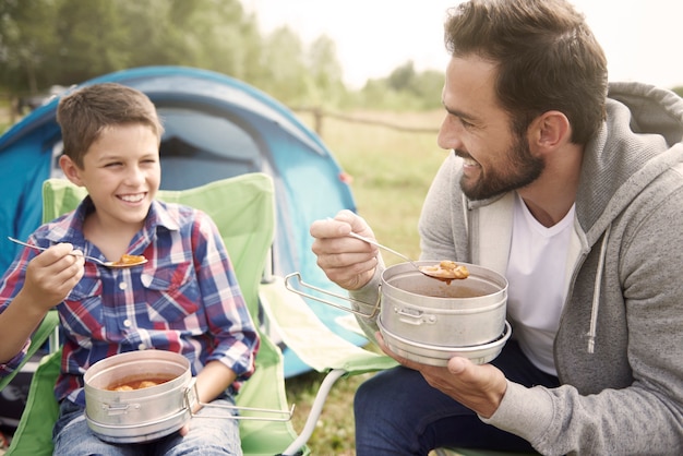 Father and his son eating dinner on camping | Free Picture on Freepik