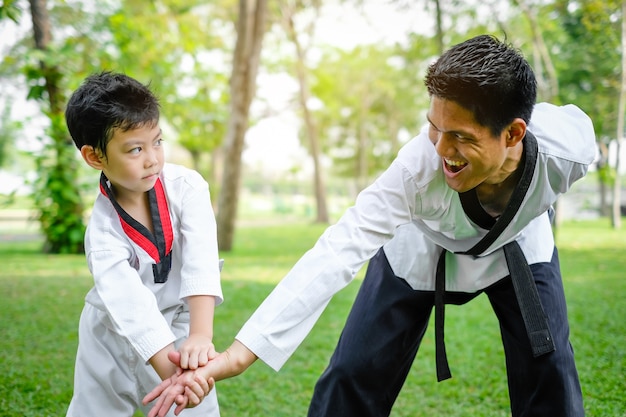 Father is teacher teaching taekwondo kids