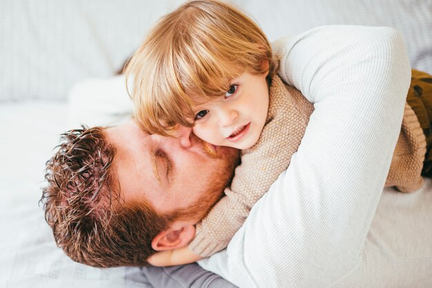 父親が子供にキスをして抱き締める 無料の写真