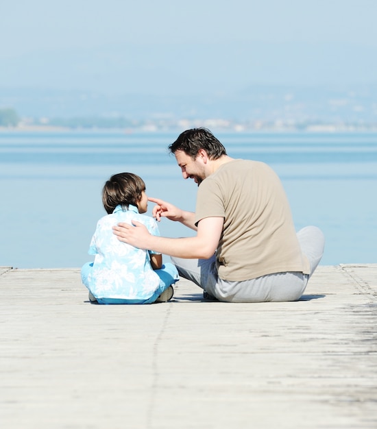 Father and son by the dock on a beautiful lake Premium Photo