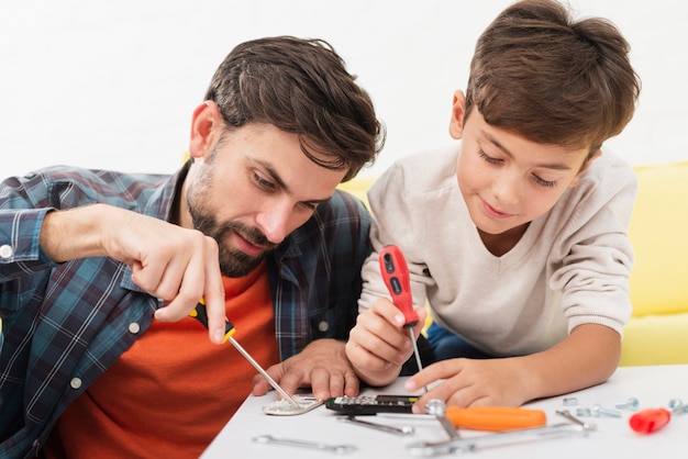 Father and son fixing toy cars Photo | Free Download