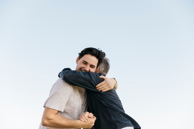 Father and son hugging on sky background Photo | Free Download