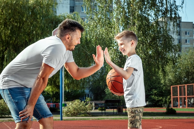 Premium Photo | Father and son play basketball together at the ...