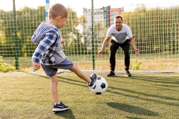 Father and son playing football Free Photo