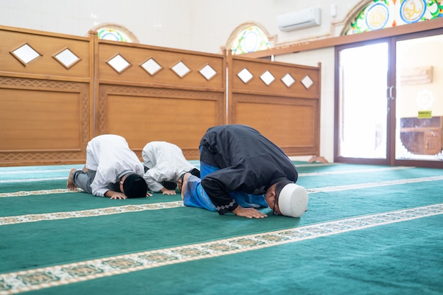 Premium Photo | Father and son praying together in the mosque