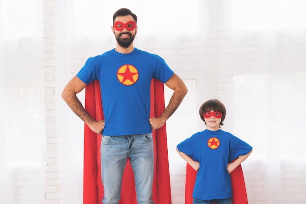 Father and son in the red and blue suits of superheroes. Premium Photo