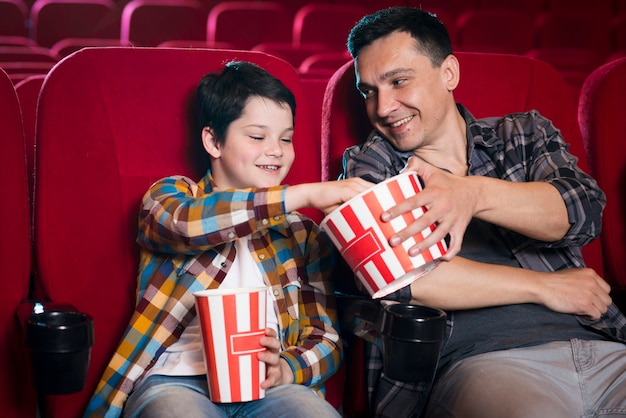 Father and son watching movie in cinema Photo | Free Download
