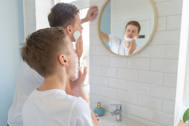 Free Photo | Father and son with shaving cream over the shoulder view