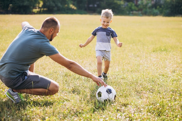 Father with son playing football at the field Free Photo