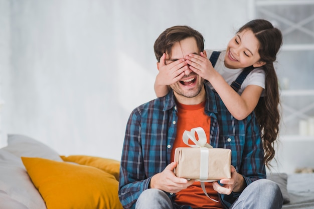 Fathers day concept with daughter covering fathers eyes Free Photo