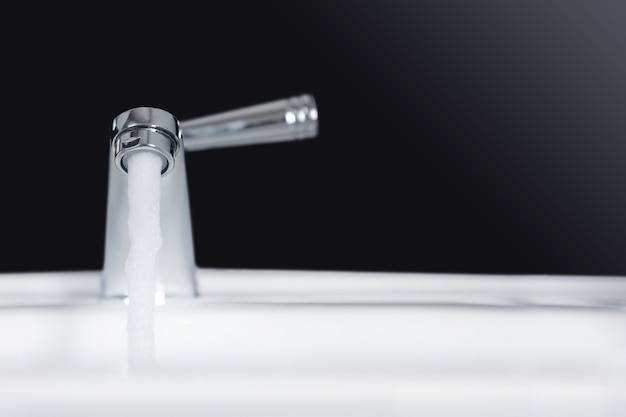 Premium Photo | Faucet and water flow on bathroom