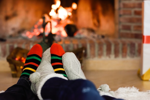 Feet in christmas socks near fireplace  Free Photo