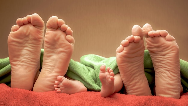 Premium Photo Feet Of Newborn Baby And Parents Together On The Bed