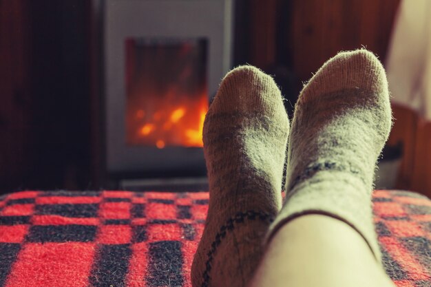 Premium Photo | Feet in wool socks at fireplace background