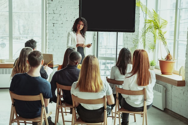 Female african-american speaker giving presentation in hall at university workshop Free Photo