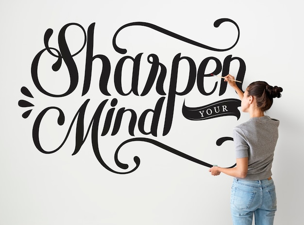 Female artist writing sharpen your mind quote on the wall Free Photo
