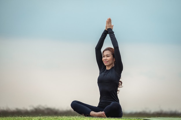 Premium Photo | Female asian yoga meditation in the open field