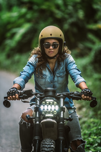 Premium Photo | Female biker driving a cafe racer motorbike