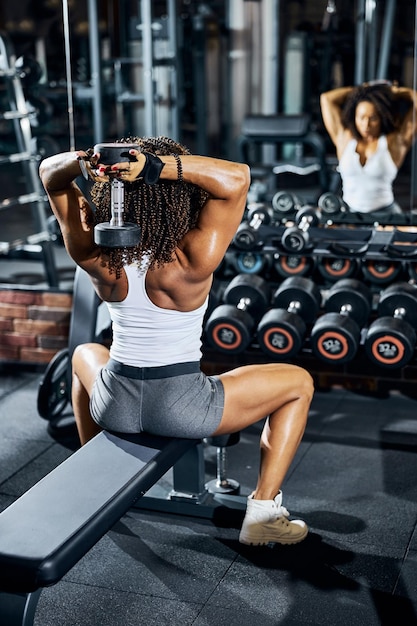 Premium Photo | Female bodybuilder working out in front of the mirror