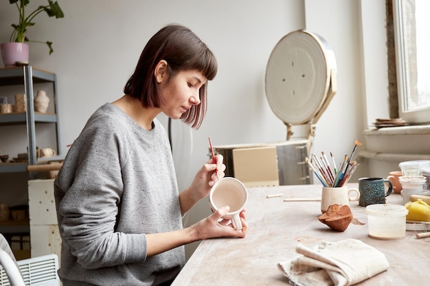 Premium Photo | Female ceramist working in pottery studio ceramists ...