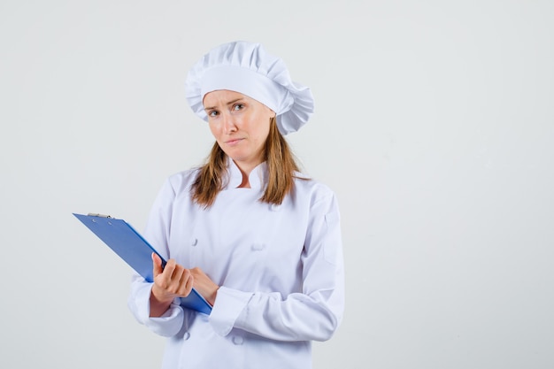 Free Photo | Female chef in white uniform holding clipboard and looking ...