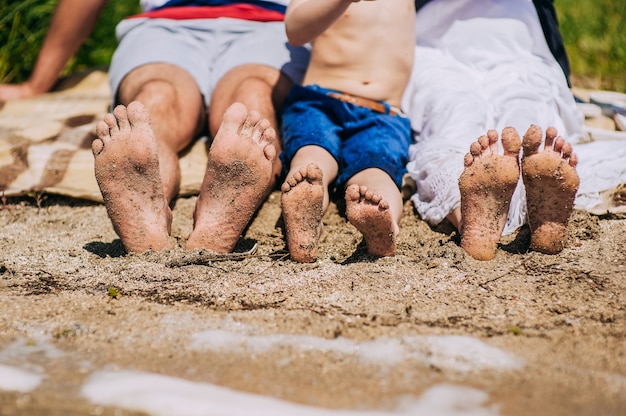 Premium Photo Female Childrens And Male Feet On A Beach Against The