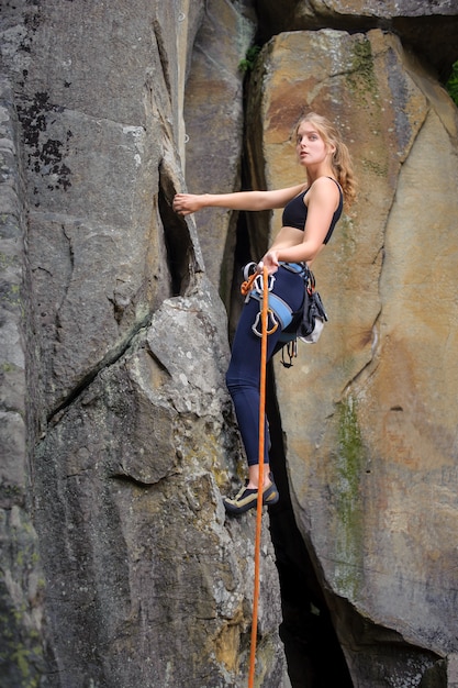 Premium Photo | Female climber climbing with rope on a rocky wall
