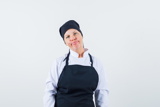Free Photo Female Cook Looking At Camera In Uniform Apron And Looking Displeased Front View