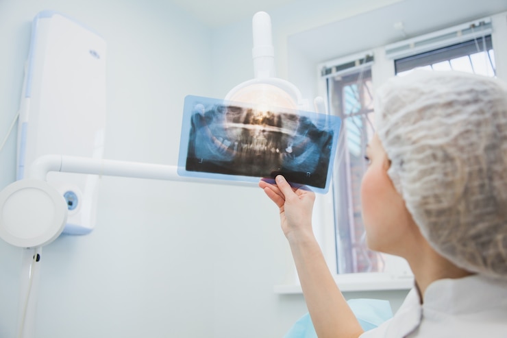  Female doctor dentist examining x-ray of human jaw. professional stomatologist checking dental x-ra