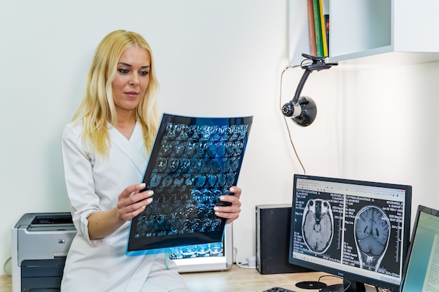 Premium Photo | Female doctor reading an x-ray image near the magnetic ...