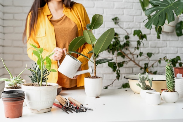 Premium Photo | Female gardener in yellow clothes taking care of the plants