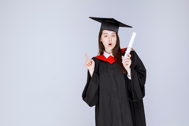 Premium Photo | Female graduate student in gown with college ...